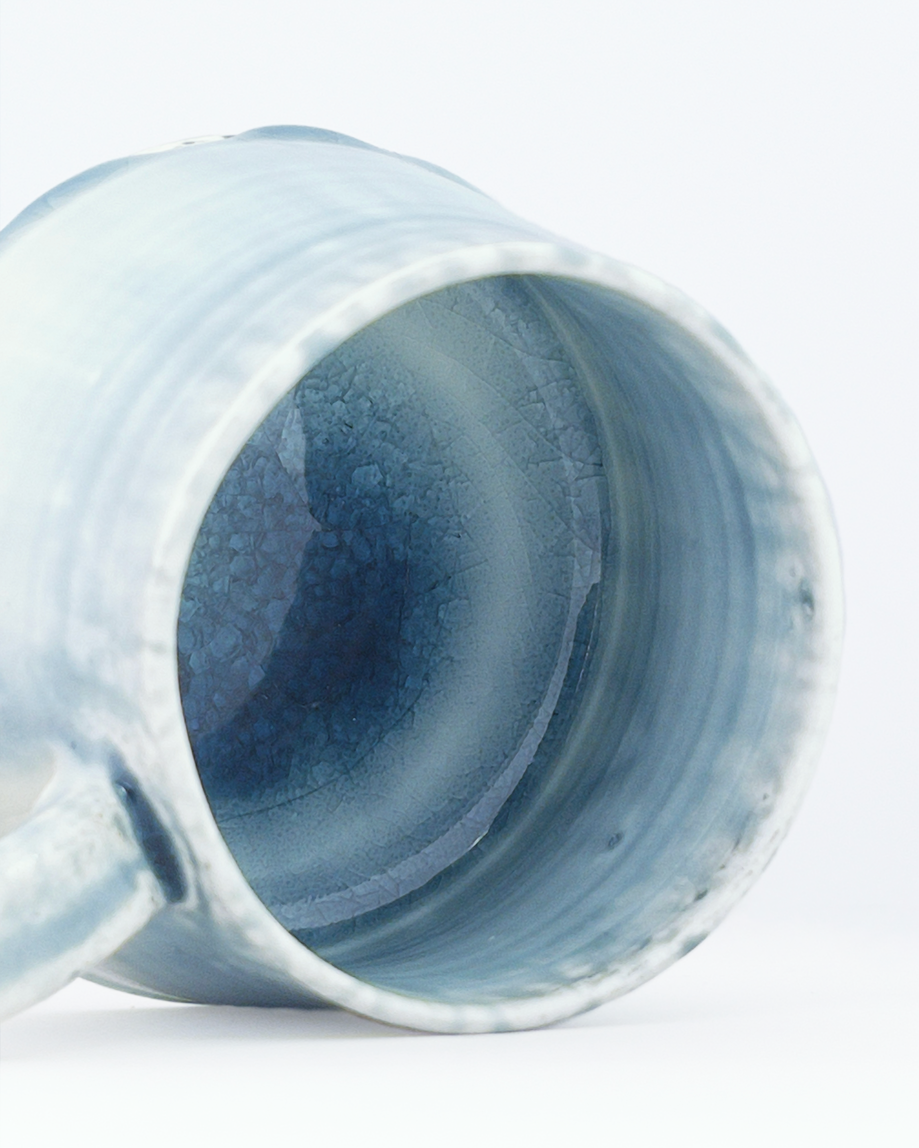 Blue ceramic mug with a crackled interior on a white background