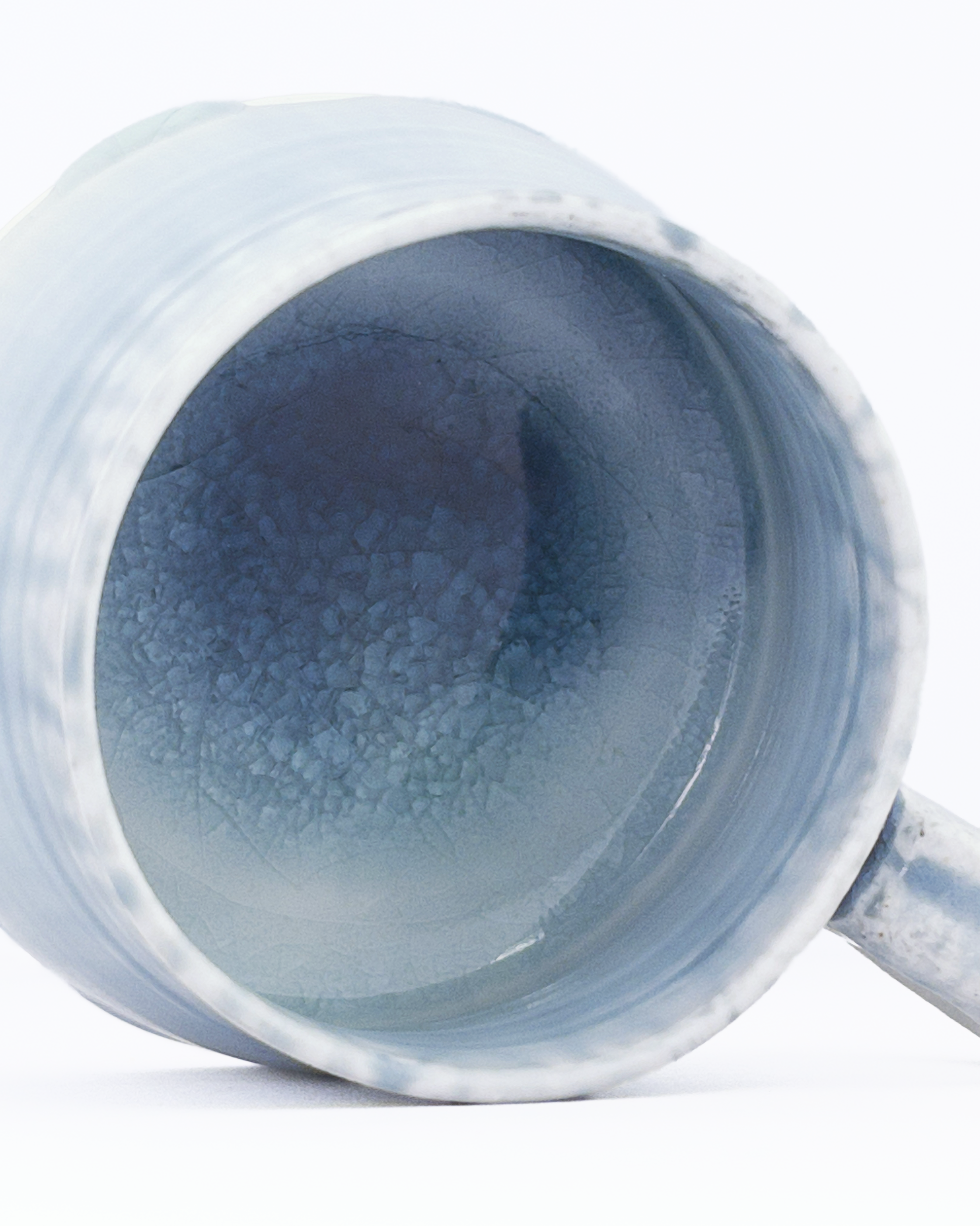 Blue ceramic mug with a crackled interior on a white background
